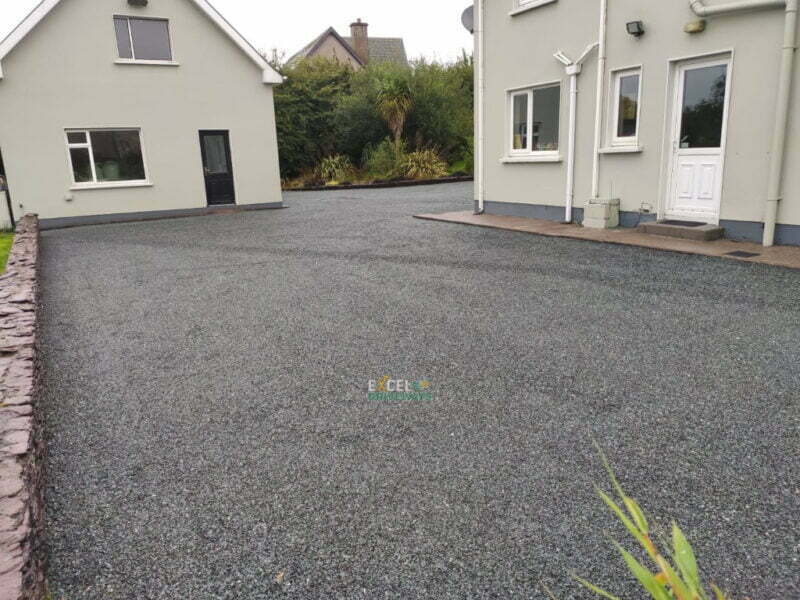 In this project we have replaced an old and weathered driveway with brand new tar and chip driveway and we also power-washed the existing paved borders and pattern to match the fresh look. Stunning transformation on a budget by Excel Driveways in Mallow, Co. Cork.